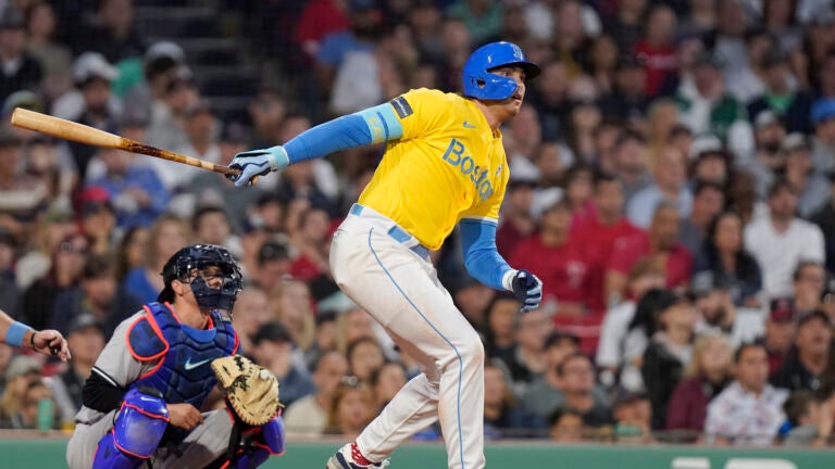 Boston Red Sox Triston Casas, right, follows through on his swing after hitting a two-run ground rule double in front of New York Yankees' Kyle Higashioka, left, allowing Jarren Duran and Alex Verdugo to score in the fifth inning of the second game of a baseball doubleheader, Sunday, June 18, 2023, in Boston.